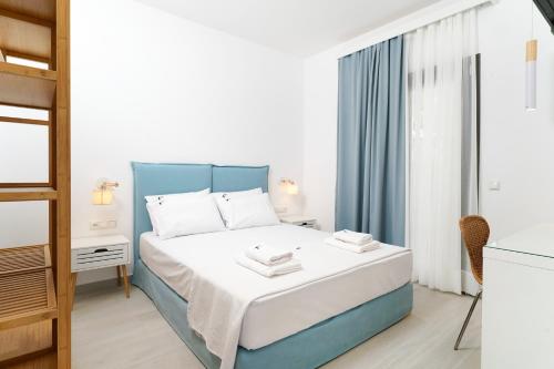 a bedroom with a blue and white bed and a window at Filoxenia Luxury Apartments in Potos