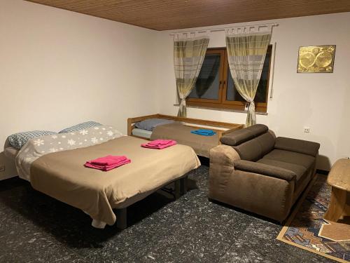 a room with two beds and a couch and a chair at Frankfurt Close Apartment in Hainburg