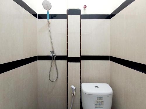 a bathroom with a shower with a toilet and a shower head at Griya Juanda Syariah near RS Dharma Husada Probolinggo Mitra RedDoorz in Sukobumi