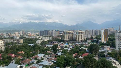 a city with buildings and mountains in the background at Heaven Apartment Mountain View in Almaty