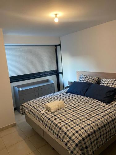 une chambre avec un lit avec une couverture à carreaux dans l'établissement Ref NASTIA - Palmes d'Or Properties, à Cannes