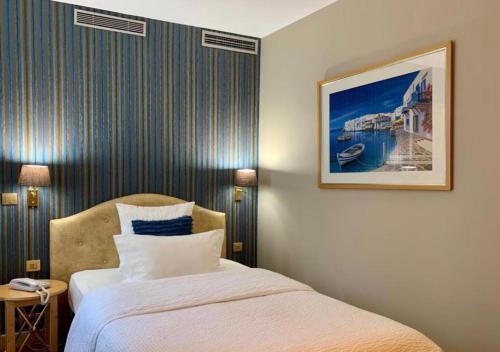 a bedroom with a bed and a picture on the wall at Hôtel Central Saint Germain in Paris