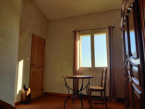 Habitación con mesa, sillas y ventana en LE CHARME DU VENTOUX en Crillon-le-Brave