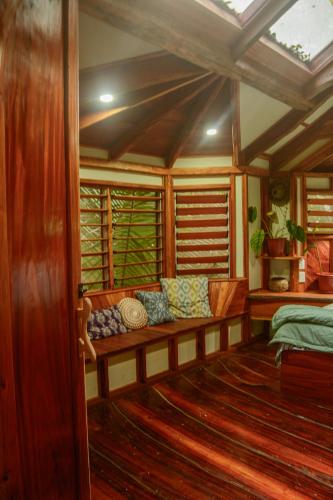 a room with a bench in a room with windows at Tukulolo Treehouses in Makaunga