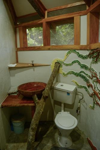 a bathroom with a toilet and a sink at Tukulolo Treehouses in Makaunga