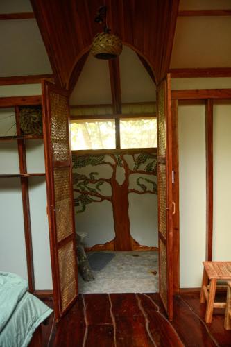 a room with a tree mural on the wall at Tukulolo Treehouses in Makaunga
