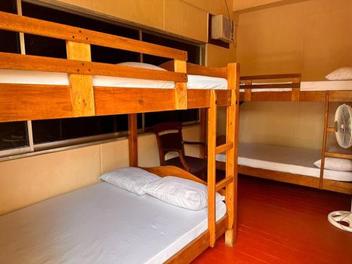 a room with two bunk beds and a chair at Hotspring Resort with Videoke in Calamba