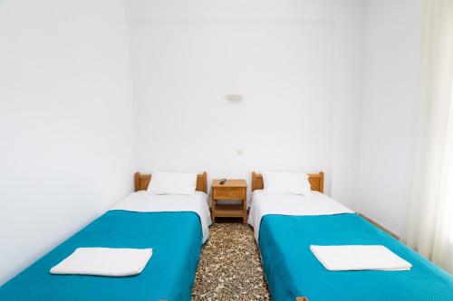 two beds sitting next to each other in a room at Armonia Apartments in Kala Nera