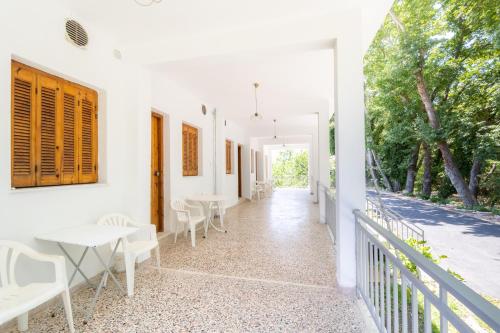 a white house with white tables and chairs at Armonia Apartments in Kala Nera