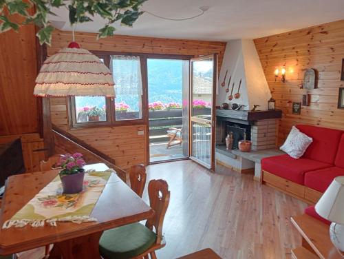 sala de estar con sofá rojo y mesa en La finestra sulle Dolomiti, en Carano