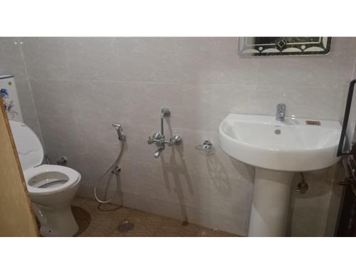 een badkamer met een wastafel en een toilet bij Hotel Shri Bhagvat Dham, Chitrakoot in Sītāpur Mūāfi