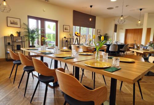Przylądek Daglezja nad Jeziorem Kórnickim في كورنيك: غرفة طعام مع طاولة وكراسي خشبية كبيرة