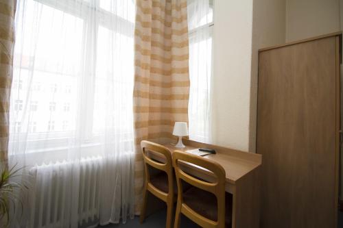 a room with a table and two chairs and a window at Hotel Spreewitz am Kurfürstendamm in Berlin
