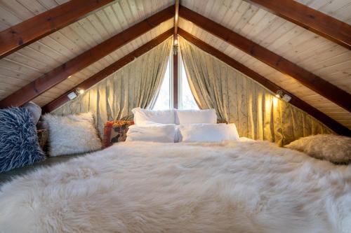 1 dormitorio con 1 cama blanca grande y ventana en הטירות הנעות ברוח, en Nimrod