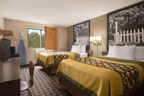 a hotel room with two beds and a flat screen tv at Super 8 by Wyndham Mayfield in Mayfield