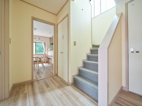 a hallway with stairs leading to a dining room at Villa Miura Beach -ヴィラ三浦海岸- in Miura