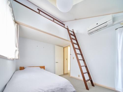 1 dormitorio con litera y escalera en Villa Miura Beach -ヴィラ三浦海岸- en Miura