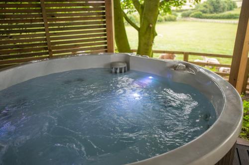 a jacuzzi tub in a backyard with a tree at Tree House in Thirsk