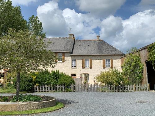 Cette grande maison en pierre est dotée d'une clôture en bois. dans l'établissement Moulin de la Fosse Soucy, à Maisons