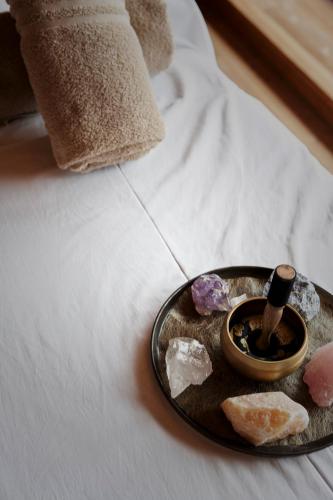 a tray with crystals and a candle on a bed at Holzhotel Forsthofalm in Leogang
