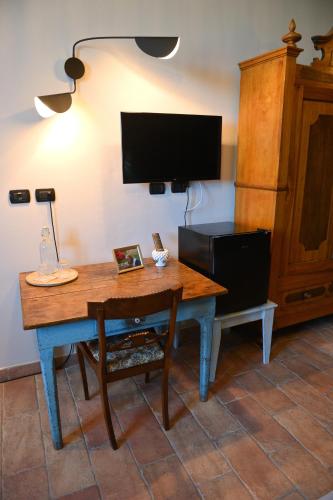a living room with a wooden table and a tv at Casale Boschi - Rifugio di Pianura in Cotignola