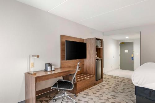 a hotel room with a desk with a television and a bed at Best Western Plus Harrisonburg in Harrisonburg