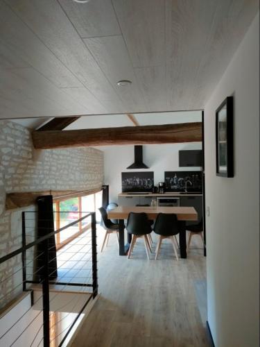une salle à manger avec une table et des chaises dans une maison dans l'établissement Gîte des Gâtines 3 étoiles, à Berthegon