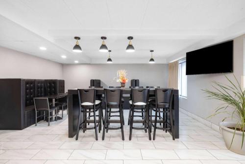 a dining room with a long table and black stools at Baymont by Wyndham Gillette in Gillette