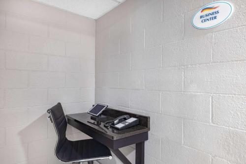 a desk with a phone and a chair in a room at Baymont by Wyndham Gillette in Gillette