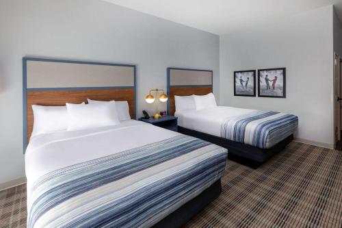 a hotel room with two beds and two lamps at AmericInn by Wyndham Mountain Home in Mountain Home
