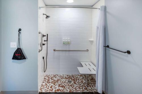 a bathroom with a shower with a tiled floor at AmericInn by Wyndham Mountain Home in Mountain Home