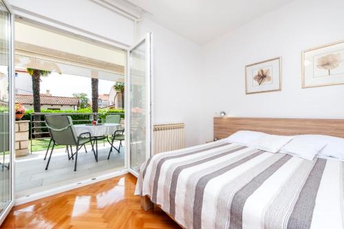 1 dormitorio con 1 cama y balcón con mesa en Apartments Magnolia, en Rovinj