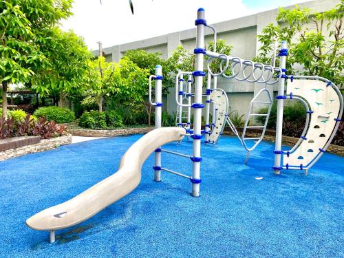 un parque infantil con un tobogán sobre una alfombra azul en Frost at Manhattan Heights TowerB, en Manila