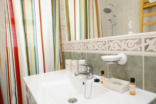 ein Badezimmer mit einem weißen Waschbecken und einem Spiegel in der Unterkunft C13 - Ameijeira Holiday Apartment in Lagos