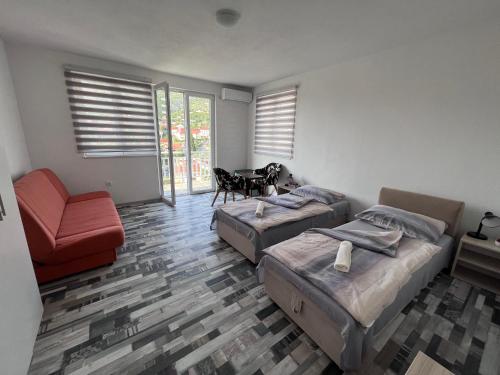 a bedroom with two beds and a chair and a table at Villa Hills in Mostar