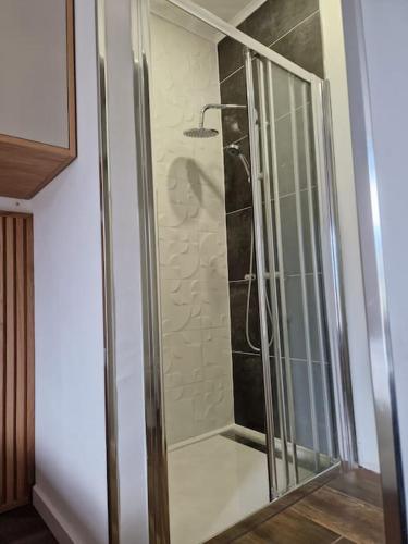a shower with a glass door in a bathroom at maison du olival in Vacalar