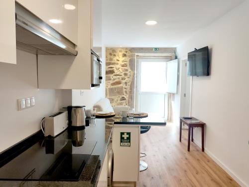 a small kitchen with a counter and a table at Casa do Beco - Foz do Douro in Porto