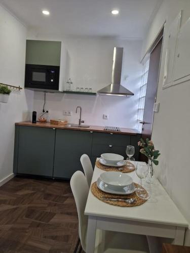 a kitchen with a white table and chairs and a sink at maison du olival in Vacalar