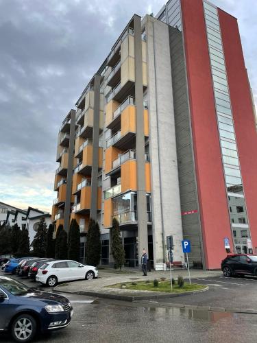 ein großes Gebäude mit Autos auf einem Parkplatz in der Unterkunft Regim Hotelier DEVA, str. Mihai Viteazu, bl. RESIDENCE !!! in Deva