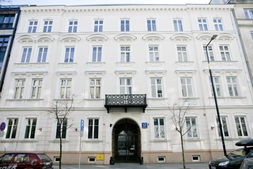 un edificio blanco con balcón en la parte superior en Apartamenty Hoża Attic Studio, en Varsovia