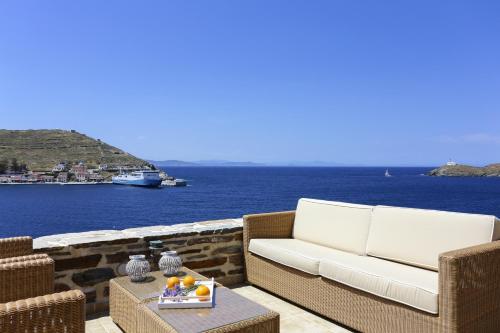 a white couch sitting on a patio overlooking the water at KEOS by the sea in Korissia