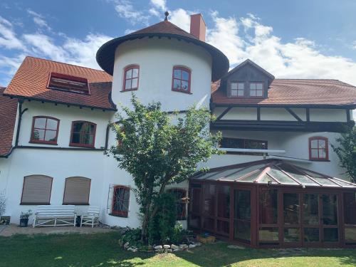 a large white building with a tree in front of it at Altmuehl Familienvilla in Treuchtlingen