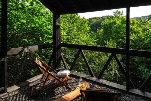 a screened in porch with a bench and a table at Hutstuf - The Fox & Private Outdoor Spa in La Roche-en-Ardenne