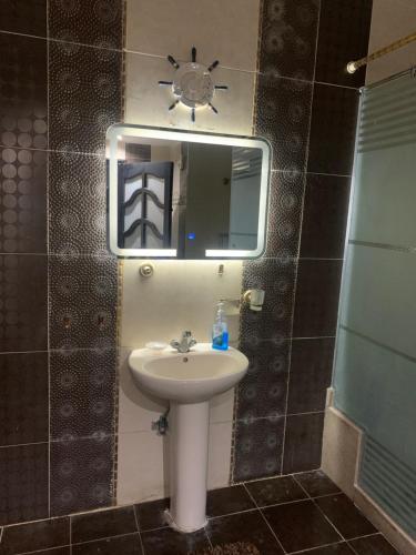 ein Bad mit einem Waschbecken und einem Spiegel in der Unterkunft Apartment with a private garden in New Cairo in Kairo