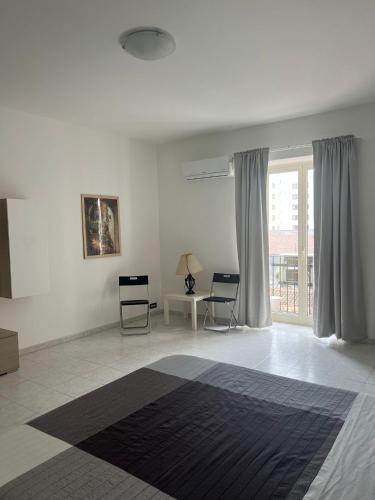 a white room with a bed and a window at Casaurora Centro Storico in Catania