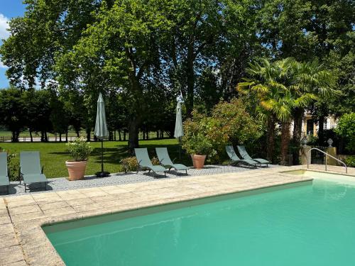une piscine avec chaises longues et parasols dans l'établissement Le Bouquet Bleu Bed and Breakfast, à Siorac-en-Périgord