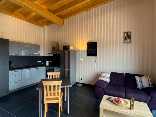 a kitchen and a living room with a couch and a table at Ferienwohnung Am Weiher Kategorie 2 in Nideggen