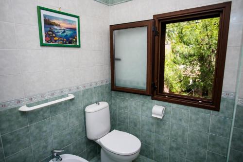 a bathroom with a toilet and a window at B&B Demarete sullo Ionio in Arenella