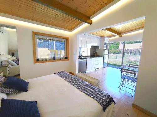 a bedroom with a large bed and a kitchen at Casa do Beco - Foz do Douro in Porto
