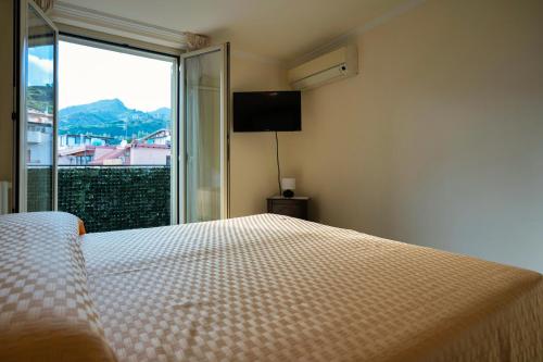 a bedroom with a bed and a large window at Atticus Apartment in Giardini Naxos